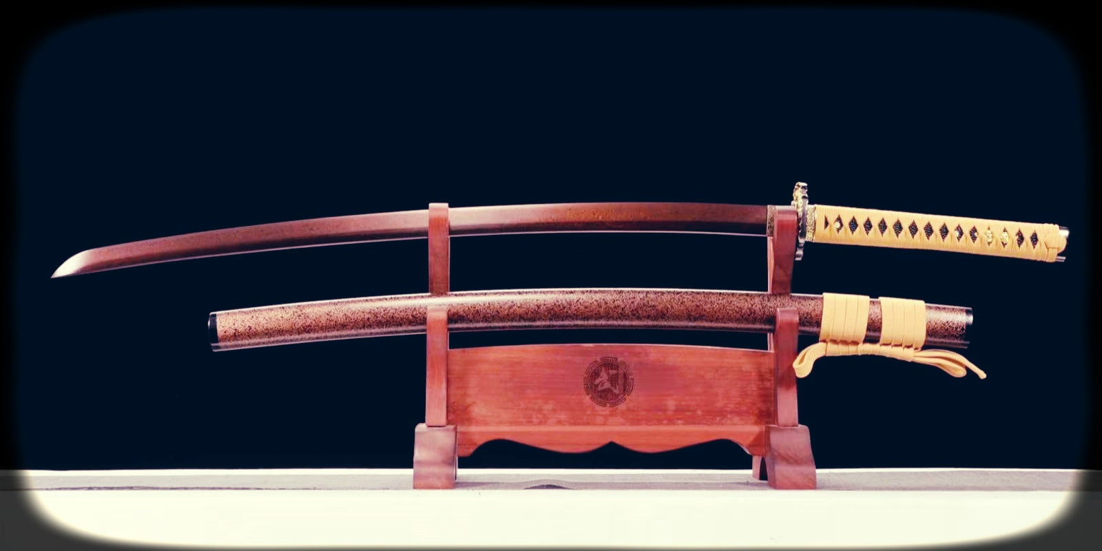 Katana displayed on a wooden stand with its scabbard below, illustrating proper sword care and the importance of dry, stable storage for long-term preservation.